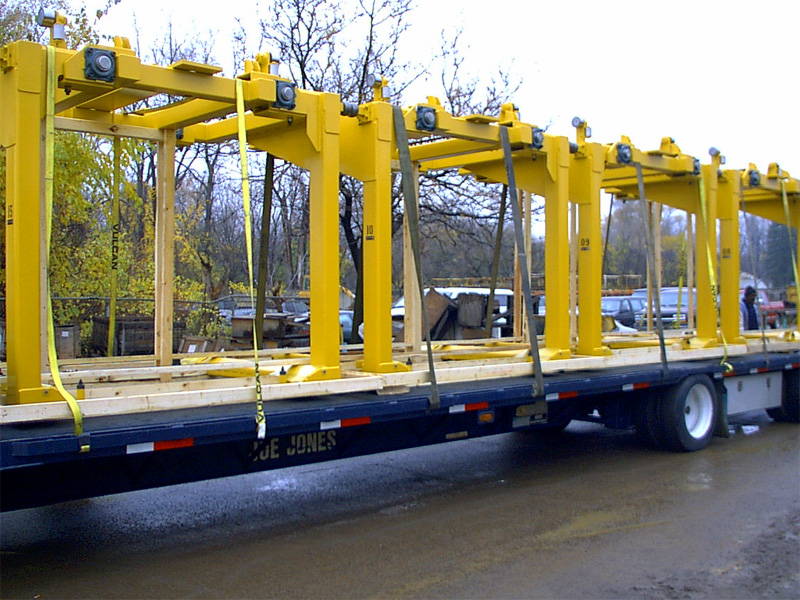 Yellow carriers strapped to a flatbed for shipment